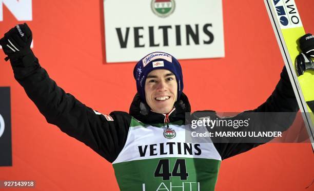 Stefan Kraft of Austria celebrates on the podium after the HS130 men's ski jumping event at the FIS World Cup in Lahti, Finland, on March 4, 2018. /...