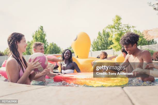 group of teenagers playing in pool - friends poolside stock pictures, royalty-free photos & images