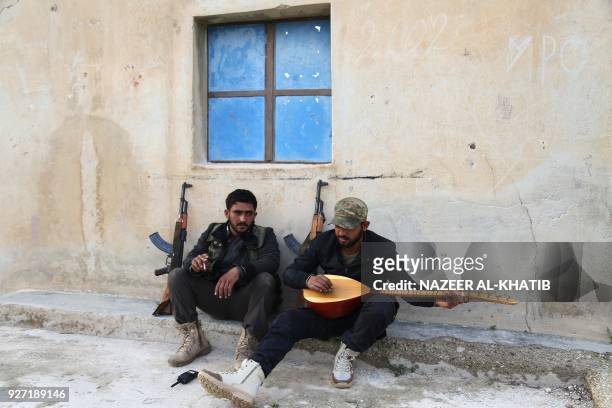 An opposition fighter plays an oud after they took control of the village of Ali Bazan, on the eastern bank of Lake Maydanki, north of the Syrian...