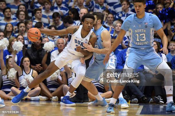 Wendell Carter, Jr. #34 of the Duke Blue Devils moves the ball against Luke Maye of the North Carolina Tar Heels at Cameron Indoor Stadium on March...