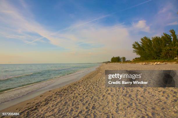 empty white sand beach with footprints, water and dramatic sky in late afternoon, captiva - captiva island florida stock pictures, royalty-free photos & images