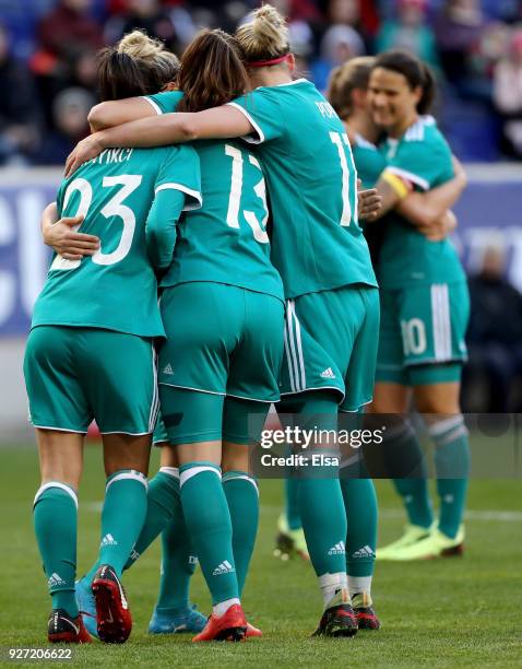 Hasret Kayikci of Germany is congratulated by teammates Sara Däbritz and Alexandra Popp after she scored in the first half against England during the...