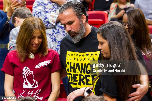 Manuel Oliver hugs his daughter, Andrea Ghersi, as her mom, Patricia, watches before the Miami Heat faced the Detroit Pistons at the AmericanAirlines...