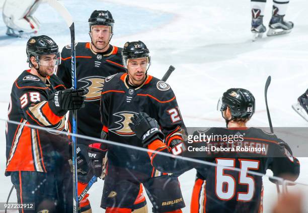 Derek Grant, Jason Chimera, and Chris Kelly of the Anaheim Ducks celebrate with Marcus Pettersson after Pettersson scored his first NHL career goal...