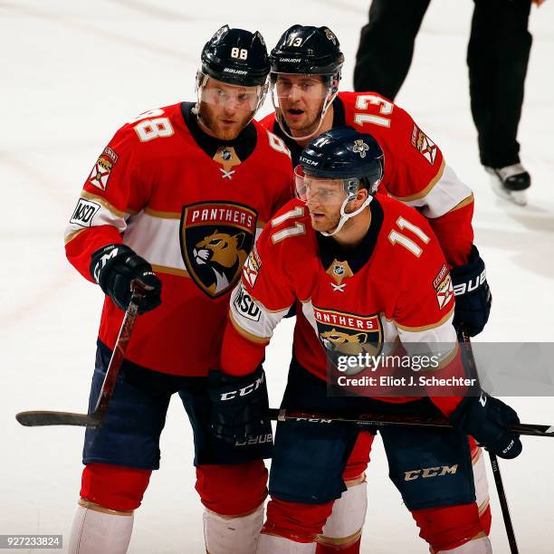 Jamie McGinn of the Florida Panthers chats with teammates Mark Pysyk and Jonathan Huberdeau just before a face off against the Philadelphia Flyers at...