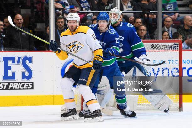 Mike Fisher of the Nashville Predators stands in front of Ben Hutton and Jacob Markstrom of the Vancouver Canucks during their NHL game at Rogers...