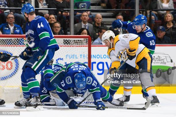 Alexander Edler and Bo Horvat of the Vancouver Canucks defend against Calle Jarnkrok of the Nashville Predators during their NHL game at Rogers Arena...