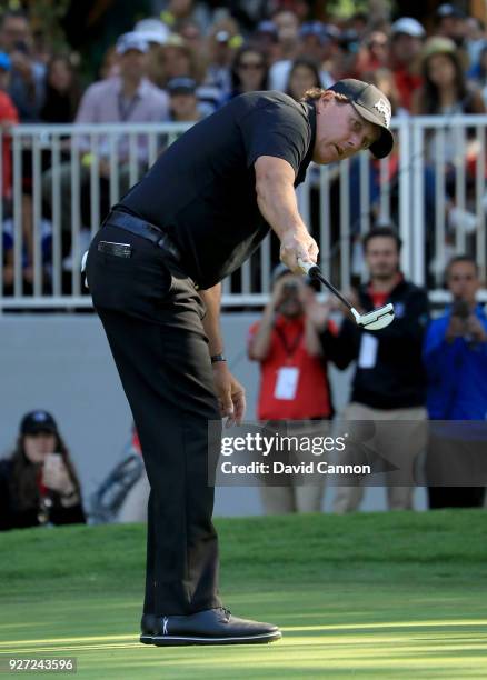 Phil Mickelson of the United States reacts as he holes a crucial birdie putt on the par 4, 16th hole during the final round of the World Golf...