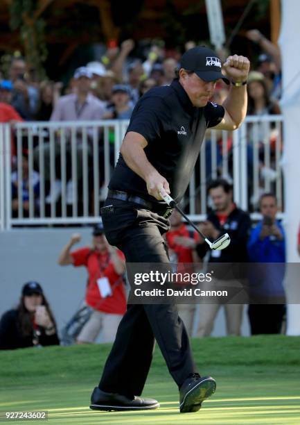 Phil Mickelson of the United States reacts as he holes a crucial birdie putt on the par 4, 16th hole during the final round of the World Golf...