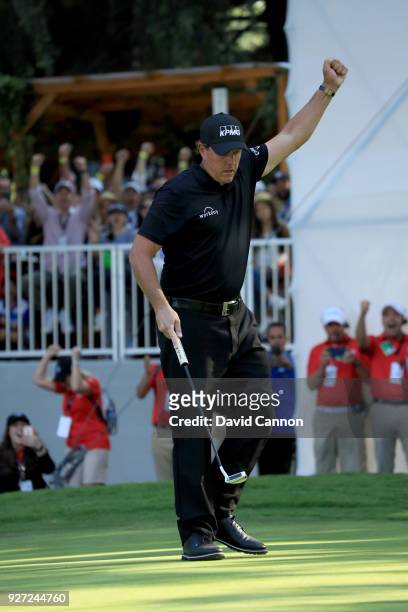 Phil Mickelson of the United States reacts as he holes a crucial birdie putt on the par 4, 16th hole during the final round of the World Golf...