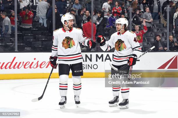 Erik Gustafsson and Vinnie Hinostroza of the Chicago Blackhawks celebrate a victory over the Los Angeles Kings at STAPLES Center on March 3, 2018 in...