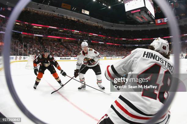 Corey Perry of the Anaheim Ducks defends against Vinnie Hinostroza and Connor Murphy of the Chicago Blackhawks during the second period of a game at...