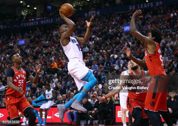 Kemba Walker of the Charlotte Hornets shoots the ball as Fred VanVleet and Lucas Nogueira of the Toronto Raptors defend during the first half of an...