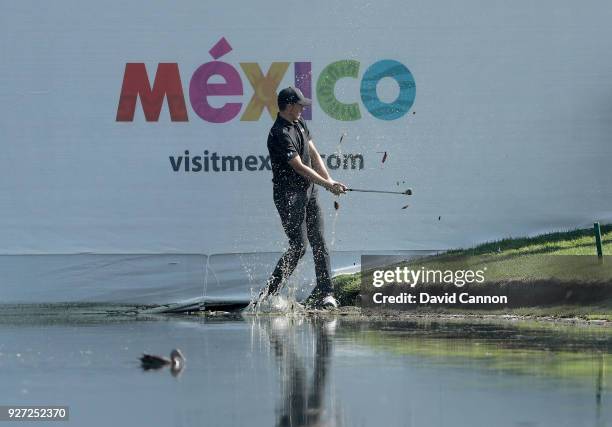 Jordan Spieth of the United States plays his second shot on the par 3, 17th hole from the waters edge during the final round of the World Golf...
