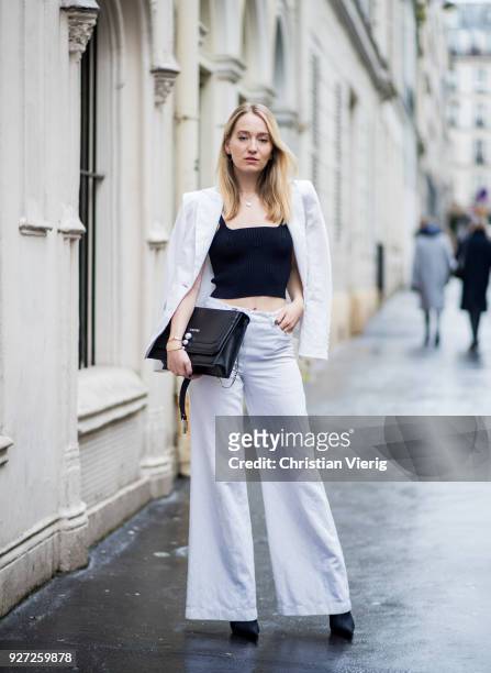 Juliane Diesner wearing total look Marc Cain including white wide leg pants, white blazer jacket, black cropped top, bag is seen during Paris Fashion...