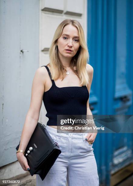 Juliane Diesner wearing total look Marc Cain including white wide leg pants, white blazer jacket, black cropped top, bag is seen during Paris Fashion...