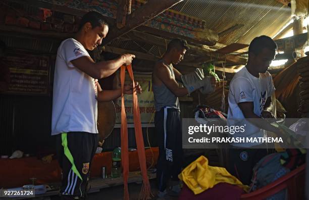 This photograph taken on February 15 shows Nepali Buddhist monks changing to their running attire at their monastery in Sindhukot village, some 80...