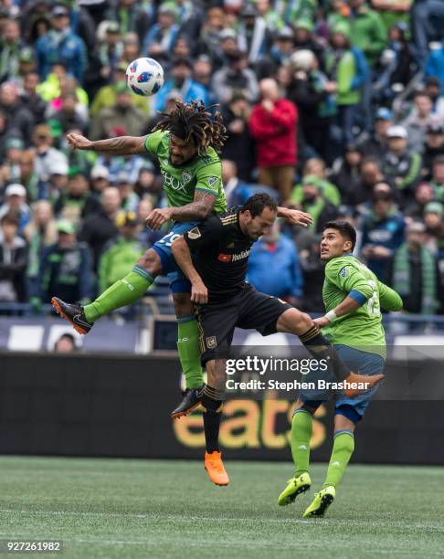 Roman Torres, left, of the Seattle Sounders and Marco Urena of Los Angeles FC go up for a header as Tony Alfaro of the Seattle Sounders watches...