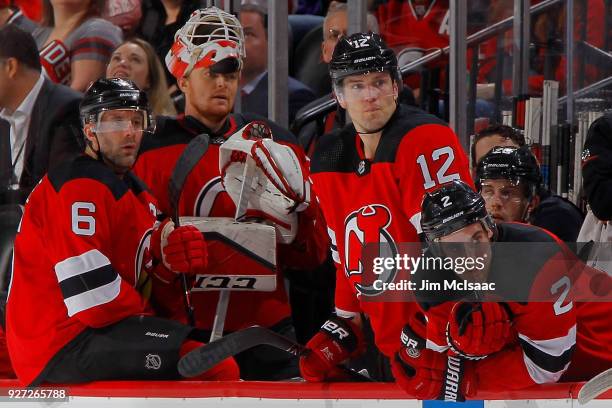 Andy Greene, Cory Schneider, Ben Lovejoy and John Moore of the New Jersey Devils look on from the bench late in the third period against the Vegas...