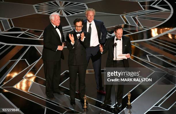 Director Bryan Fogel delivers a speech next to US producer Dan Cogan after they won the Oscar for Best Documentary Feature for "Icarus" during the...