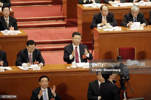 Xi Jinping, China's president, second row center, applauds as Zhang Dejiang, chairman of the Standing Committee of the National People's Congress ,...