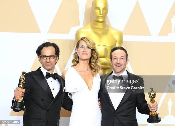 Actor Laura Dern with producer Dan Cogan and director Bryan Fogel, winners of the Best Documentary Feature for Icarus pose in the press room during...