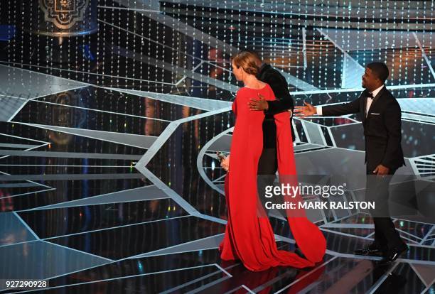 Actress Allison Janney leaves the stage with actor Mahershala Ali after she won the Oscar for Best Supporting Actress in "I, Tonya" during the 90th...
