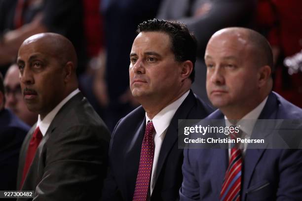 Head coach Sean Miller of the Arizona Wildcats sits watches alongside associate head coach Lorenzo Romar and assistant coach Mark Phelps during the...