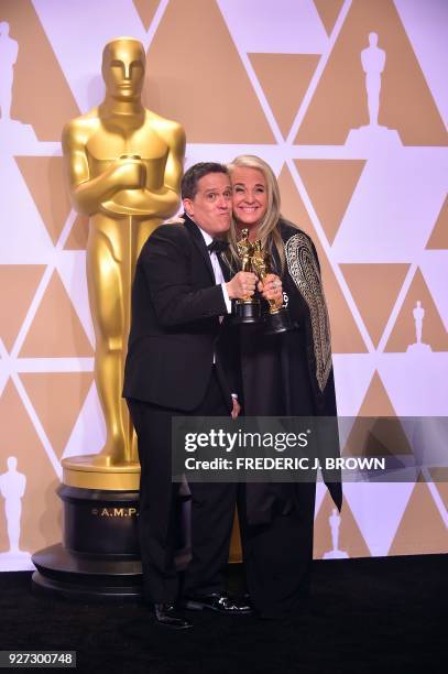 Filmmakers Lee Unkrich and Darla K. Anderson, pose in the press room with the Oscar for Best Animated Feature Film for "Coco," during the 90th Annual...