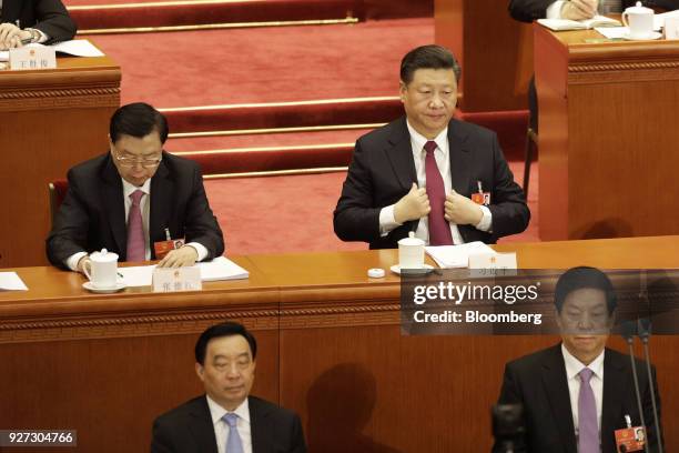Xi Jinping, China's president, second row right, adjusts his suit as Zhang Dejiang, chairman of the Standing Committee of the National People's...