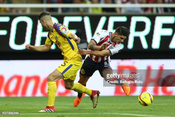 Alan Pulido of Chivas fights for the ball with Guido Rodriguez of America of America during the 10th round match between Chivas and America as part...