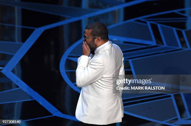 Director Jordan Peele reacts as he arrives on stage after he won the Oscar for Best Original Screenplay for "Get Out" during the 90th Annual Academy...