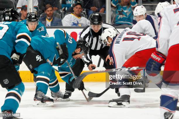 Logan Couture of the San Jose Sharks and Alexander Wennberg of the Columbus Blue Jackets faceoff at SAP Center on March 4, 2018 in San Jose,...