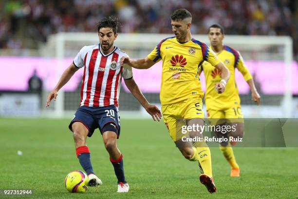 Rodolfo Pizarro of Chivas fights for the ball with Guido Rodriguez of America during the 10th round match betwee fights for the ball with Andres...