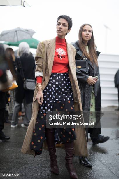 Yasmin Sewell is seen on the street attending Balenciaga during Paris Women's Fashion Week A/W 2018 wearing a trench coat, an orange turtleneck, a...
