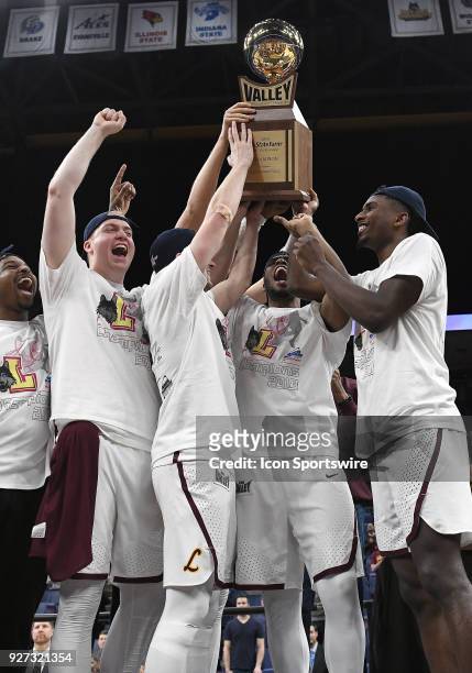 The Loyola team hoists the championship trophy after winning the Missouri Valley Conference Basketball Tournament championship game between Loyola...