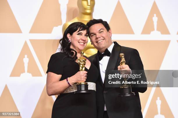 Composers Kristen Anderson-Lopez and Robert Lopez, winners of the Best Original Song award for 'Remember Me' from 'Coco,' pose in the press room...