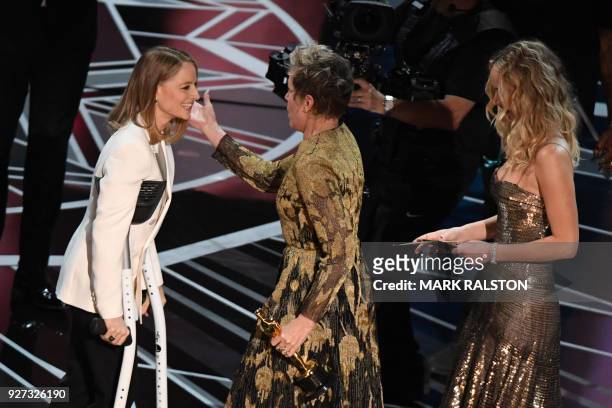 Actress Frances McDormand accepts the Oscar for Best Actress in "Three Billboards outside Ebbing, Missouri" from US actresses Jodie Foster and...