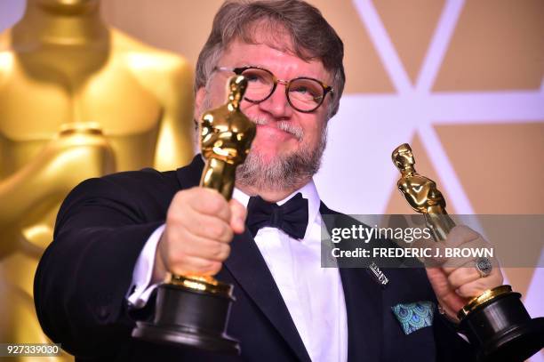 Director Guillermo del Toro poses in the press room with the Oscars for best picture and best director during the 90th Annual Academy Awards on March...