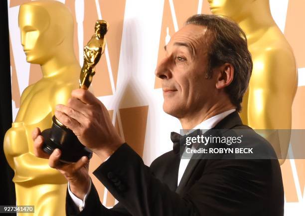 French composer Alexandre Desplat poses in the press room with the Oscar for Best Original Score for "The Shape of Water" during the 90th Annual...