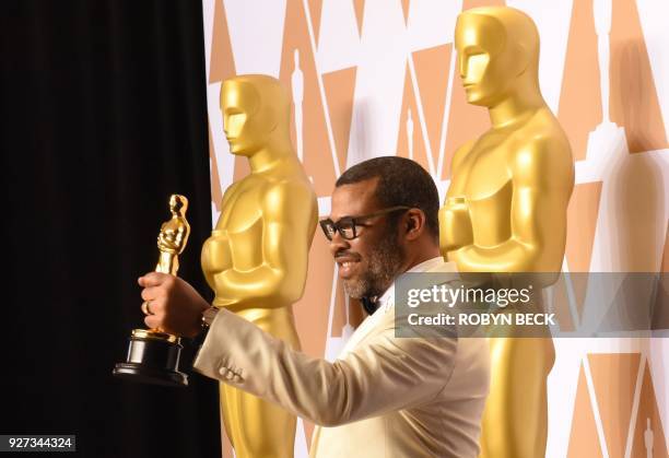 Director Jordan Peele poses in the press room with the Oscar for Best Original Screenplay for "Get Out" during the 90th Annual Academy Awards on...