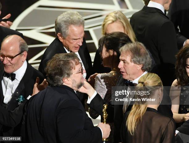 Director Guillermo del Toro with actors Richard Jenkins and Warren Beatty after his Best Picture win for 'The Shape of Water' onstage during the 90th...