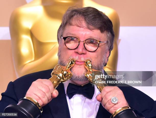 Director Guillermo del Toro poses in the press room with the Oscars for best picture and best director during the 90th Annual Academy Awards on March...