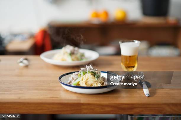 cream sauce spaghetti - beer on table stock pictures, royalty-free photos & images