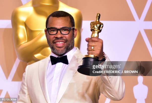 Director Jordan Peele poses in the press room with the Oscar for best original screenplay during the 90th Annual Academy Awards on March 4 in...