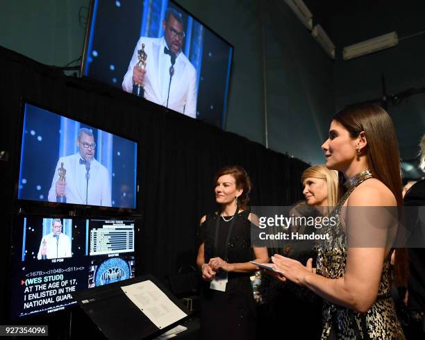 In this handout provided by A.M.P.A.S., actor Sandra Bullock watches a video feed of writer writer Jordan Peele accept the Best Original Screenplay...