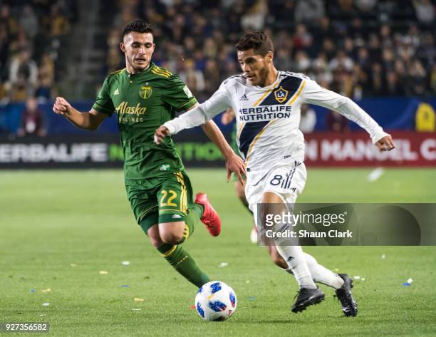 Jonathan dos Santos of Los Angeles Galaxy races in on goal as Cristhian Paredes of Portland Timbers defends during the Los Angeles Galaxy's MLS match...