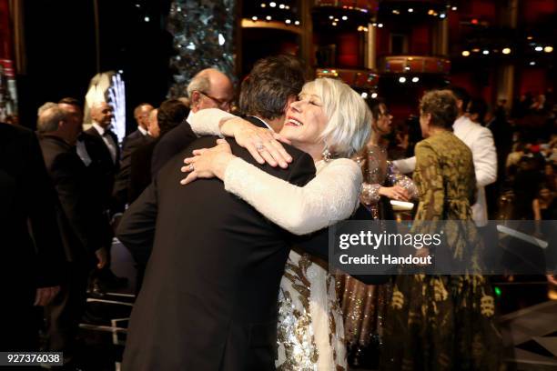 In this handout provided by A.M.P.A.S., Alexandre Desplat and Helen Mirren attend the 90th Annual Academy Awards at the Dolby Theatre on March 4,...