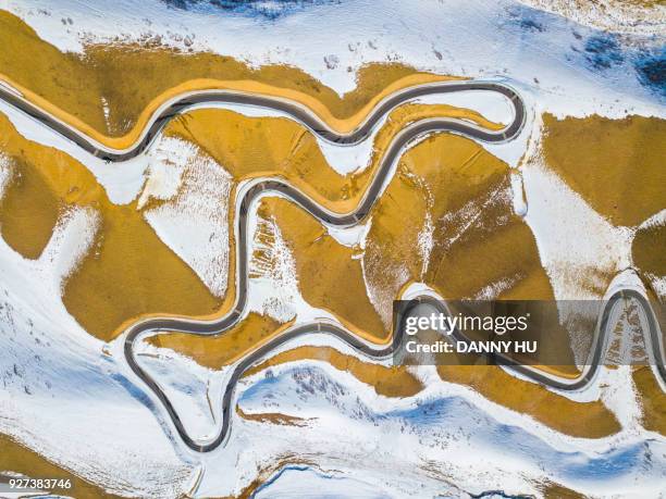 aerial view of roads in mountain range in xinjiang, west china - bergkette stock-fotos und bilder