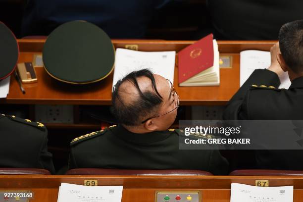 Military delegate waits before the opening session of the National People's Congress, China's legislature, in Beijing's Great Hall of the People on...